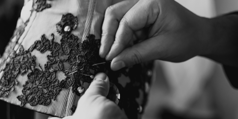 Japanese craftsman meticulously attaching delicate lace pieces to a garment sleeve